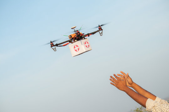 Drone Delivering First Aid Box or medicine to costumer hand during covid-19 or coronavirus lockdown - Advancing Medical Industry Logistics for Drug Transport concept.
