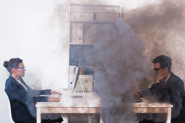 Close-up of fire burning inside the office cabin during works. Men and women office workers in a...