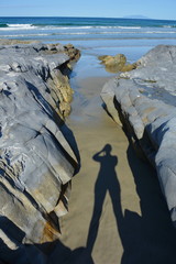 Silhouette of a photographer on Mangawhai Heads beach, New Zealand