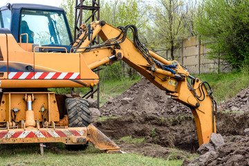 Fototapeta premium The modern excavator performs excavation work on the construction site
