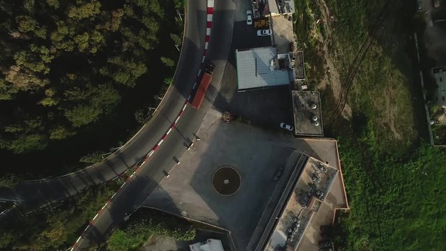 Medium aerial tracking and circle shot above red semi trailer around turn