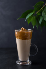 Dalgona coffee in a glass cup on a black background