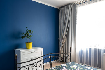Bedroom with classic blue walls. Iron bed.