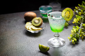Cold cocktail kiwi drink in a glass with fresh fruits on black background