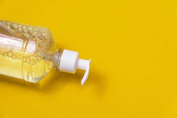 Container with alcohol gel on the orange background