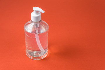 Container with alcohol gel on the red background