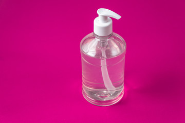 Container with alcohol gel on the red background