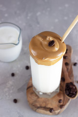 Iced Dalgona coffee, a trendy fluffy creamy whipped coffee. Trend Korean drink with instant coffee in glass. 