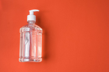 Container with alcohol gel on the red background