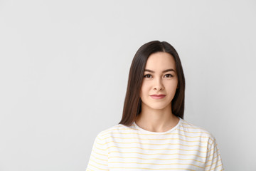 Portrait of beautiful young woman on grey background