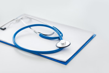 Clipboard and stethoscope on table in clinic