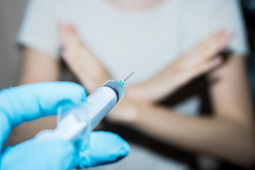 .Stop vaccinations. Say no to the coronavirus vaccines. A syringe in the doctor’s hand and a...