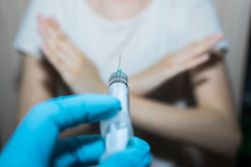 .Stop vaccinations. Say no to the coronavirus vaccines. A syringe in the doctor’s hand and a...