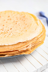 Board with tasty blini on table, closeup