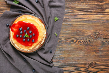 Tasty blini with berries on table