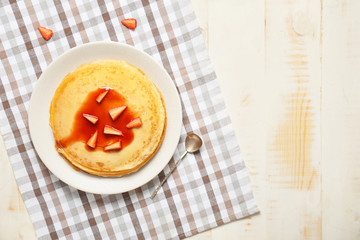 Tasty blini with berries on table