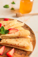 Plate with tasty blini and berries on table, closeup