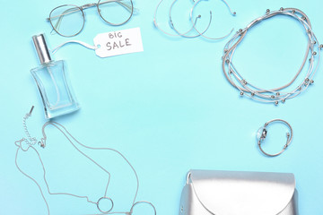Frame made of perfume for sale with accessories on color background