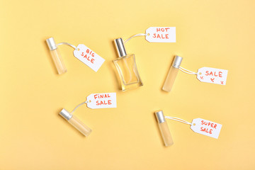 Bottles of perfumes for sale on color background