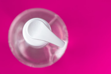 Container with alcohol gel on the red background