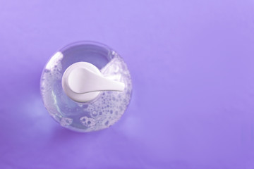 Container with alcohol gel on the light blue background