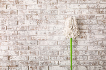 Floor mop on brick background