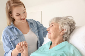 Obraz premium Young woman visiting her grandmother in hospital