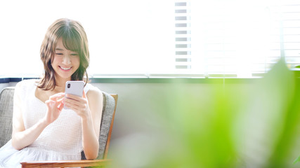 スマホを使う女性 © metamorworks