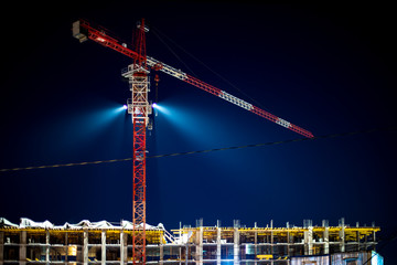 Construction crane, building site lighting at night, construction of an apartment building, the...