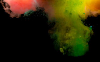 Abstract art powder paint on black background. Movement abstract frozen dust explosion multicolored on black background.