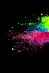 Abstract art powder paint on black background. Movement abstract frozen dust explosion multicolored on black background.