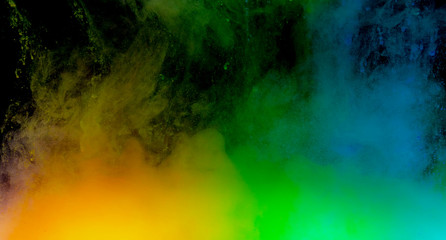 Abstract art powder paint on black background. Movement abstract frozen dust explosion multicolored on black background.