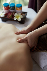 Hands massage back and shoulders in spa