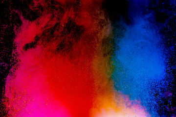 Abstract art powder paint on black background. Movement abstract frozen dust explosion multicolored on black background.