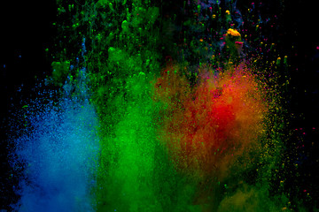 Abstract art powder paint on black background. Movement abstract frozen dust explosion multicolored on black background.