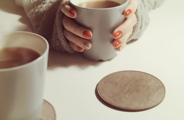cup in female hands in a warm plaid. cozy home evening or morning breakfast with coffee and tea    