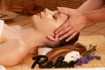 Obraz na płótnie Canvas Beautiful young woman having a face massage in spa salon - wellness