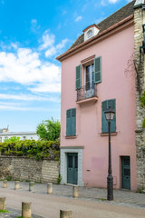 Paris, France, famous pink house and buildings in Montmartre, in a typical street
