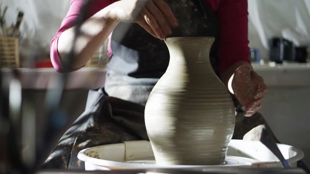 woman potter makes pitcher on a potter's wheel 4k