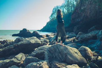 Pregnant woman walking on rock by the sea