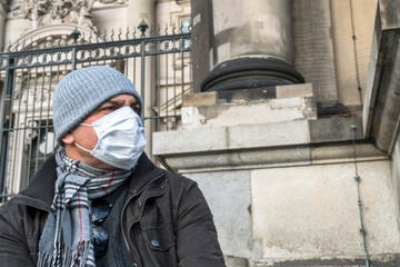 Disease outbreak, COVID-19 Coronavirus SARS-CoV-2 pandemic. Man covering his face with a medical...