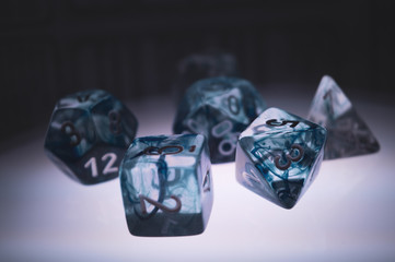 Set of transparent polyhedral gaming dice lit from below so they seem to float