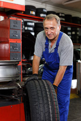 Mechanician removing tire from wheel disc