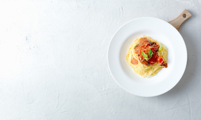 Italian pasta in a white plate with tomato sauce. Top view
