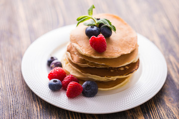 Homemade american pancakes with fresh blueberry and raspberries. Healthy morning breakfast. Rustic style