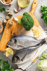 Fresh food background Raw cooking ingredients for tasty and healthy food. Fresh fish, vegetables, herbs and legumes top view