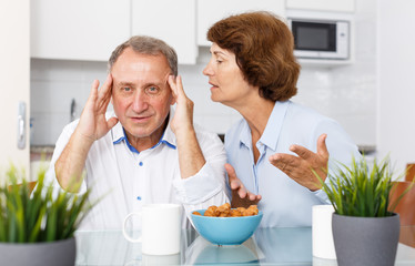 Unhappy mature couple discussion while quarrel in home interior