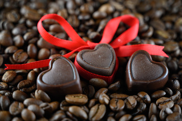 Heart shaped chocolates on a bean background. Valentine's day idea. Coffee bean wallpaper.