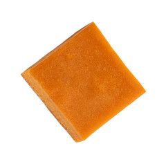 Caramel piece  isolated on white background. Sweet toffee candy top view, flat lay