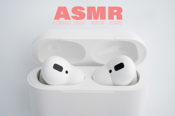 Autonomous sensory meridian response, ASMR text. Earphones to hear sound waves as a symbol of enjoying sounds, whisper or music.